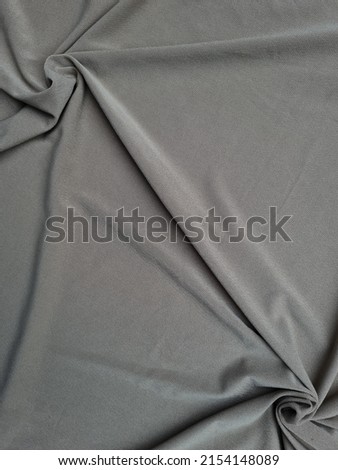 Abstract gray textured fabric background with folds forming a shadow