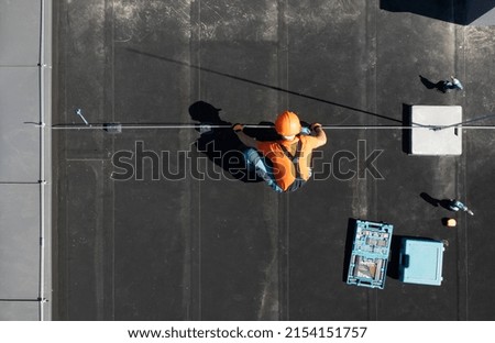 Residential Building Lightning Protection Rod Installation Performed by Professional Worker Aerial View.