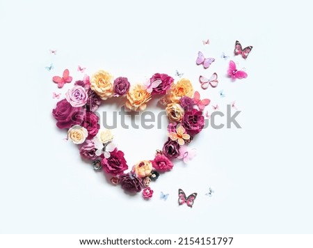 Happy mothers and Valentines day. Bouquet of colorful assorted roses in heart shape and butterfly on white background.