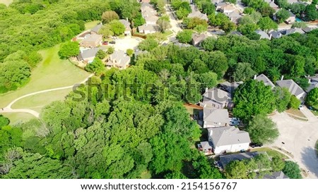 Aerial view upscale residential area with lush green trees, trail system, natural background at Flower Mound, Texas. Fly over parkside Dallas suburbs single family homes with large backyard Royalty-Free Stock Photo #2154156767