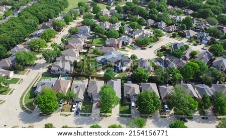 Top view an established neighborhood with matured trees and two story houses in Flower Mound, Texas, US. Upscale parkside Dallas suburbs single family homes with large backyard lush green Royalty-Free Stock Photo #2154156771