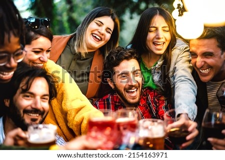 Happy friends having fun drinking at house dinner pic nic bbq party - Mixed age range people toasting drinks at fancy restaurant garden together - Staycation life style concept on warm night filter