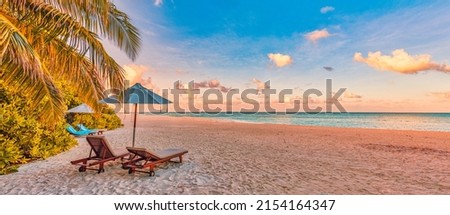 Beautiful panoramic nature. Tropical beach sunset as summer island landscape with chairs umbrella palm leaves calm sea shore, coast. Luxury travel panoramic destination banner for vacation or holiday Royalty-Free Stock Photo #2154164347
