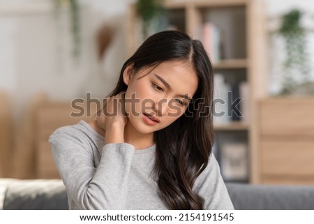 An Asian woman  do self massage at her neck and shoulders. She has got back and pain on her muscles. Massage could help her release her pain but the best way is to asking the advices from the doctor. Royalty-Free Stock Photo #2154191545