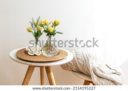 Home composition with rose flowers in a vase in the interior of a white room, copy space.