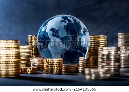 Globe and stack with coins. Money makes the world go round Royalty-Free Stock Photo #2154195865
