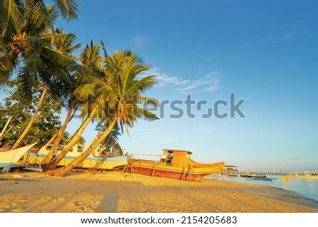 Landscape with tropical white sand beach with fishing boats. Siargao Island, Philippines.