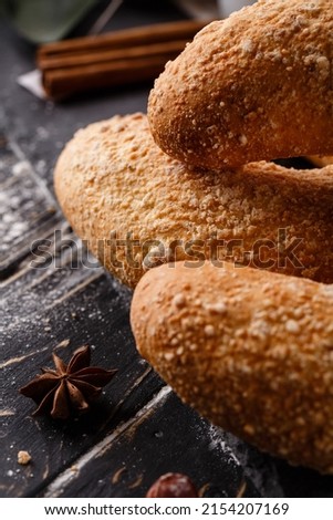 Pastries. Sweet buns on dark wooden table with an anise star and cinnamon sticks around them. Rustic and christmas concept. Selective focus. Blurred background. Banner.