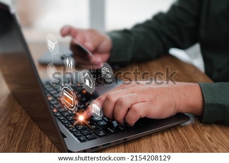 Man using laptop computer tying credit card detail for paying online monthly expenses and holding a credit card in hand, with screen icon concept