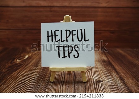 Helpful Tips text on paper card on wooden background