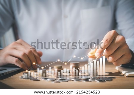 Business man putting coins Business growth and investment chart, strategic planning to increase profits from doing business, long-term investment planning. Royalty-Free Stock Photo #2154234523