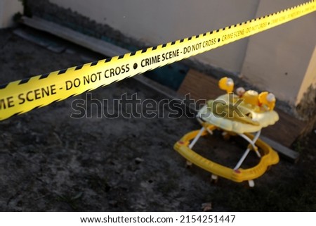 Crime scene tape for covering the area cordon. Yellow tape with blurred forensic law enforcement background in cinematic tone and copy space