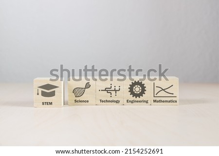 Scientific symbols on wooden building blocks with words. One block pulled slightly forward. Five wood blocks on white background. Education of the sciences and math in pictures and letters.