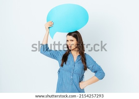 Angry dissatisfied young woman with blank speech bubble looking sullenly at camera, disagree statement concept