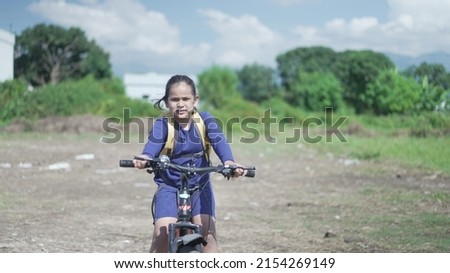 An Indian Kid cycling on a road, near a sugarcane field in a rural area of Uttarakhand, India. Physical fitness of an Indian boy. High-quality image.