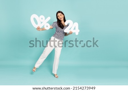 Portrait of Asian business woman standing and holding 0% number or zero percent and twenty four number isolated on green background