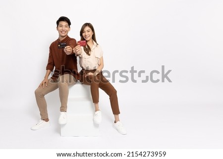 Happy young Asian couple smiling, showing and presenting credit card for paying online business isolated on white background Royalty-Free Stock Photo #2154273959