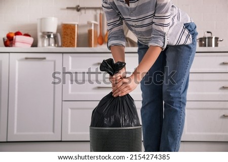 Woman taking garbage bag out of bin at home, closeup Royalty-Free Stock Photo #2154274385