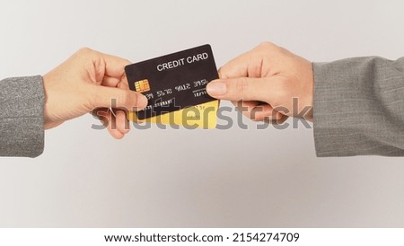 Hands are sent and receive black and gold credit cards on white background.	

