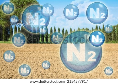 N2 nitrogen gas is the main constituent of the earth's atmosphere - concept with nitrogen molecules against a natural rural scene Royalty-Free Stock Photo #2154277917
