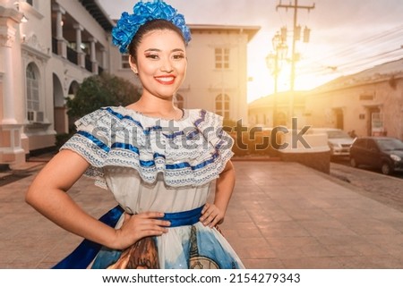 Traditional dancer from Nicaragua smiling and looking at camera at sunset wearing the typical costume of Central America, similar to used in Mexico, Honduras, El Salvador, Guatemala and South American Royalty-Free Stock Photo #2154279343