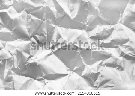 Background from crumpled paper in silver color. Paper with scuffs and waves