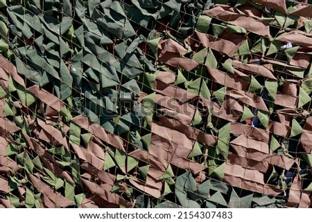 Military camouflage net. Army Military Mask. Protective Khaki Disguise Surface. War Engineering Structure Defense Military Vehicle Or Equipment.
