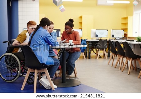 Vibrant full length shot of diverse group of students studying together at table in college lab, copy space Royalty-Free Stock Photo #2154311821