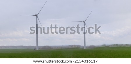 Modern wind turbine on cloudy sky background. alternative energy sources. Wind turbines in field under cloudy weather.