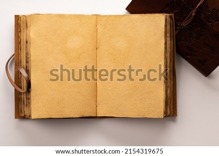 Antique leather-bound notebook or diary with antique papyrus-type pages with white background and space for text inside the notebook.