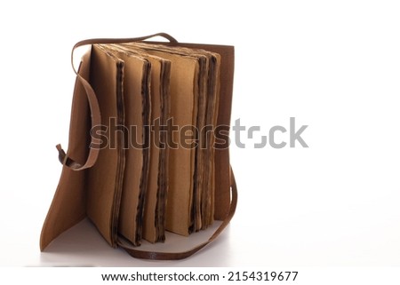 Antique leather-bound notebook or diary with antique papyrus-type pages with white background and space for text.