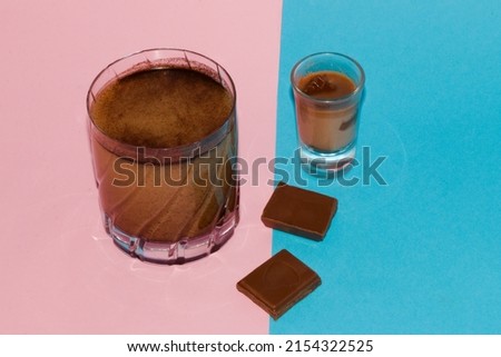 small and large cups of hot chocolate on a pink-blue background, enjoying the idyllic scene
