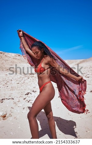 Egyptian woman on the beach in Hurghada, Orange Bay, wearing a red bikini in the Red Sea.