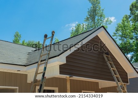 Aerial view the asphalt shingles roofing waterproofing for new house in covered corner roof shingles on under construction Royalty-Free Stock Photo #2154334019