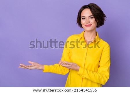 Photo of nice young lady indicate empty space wear yellow shirt isolated on violet color background