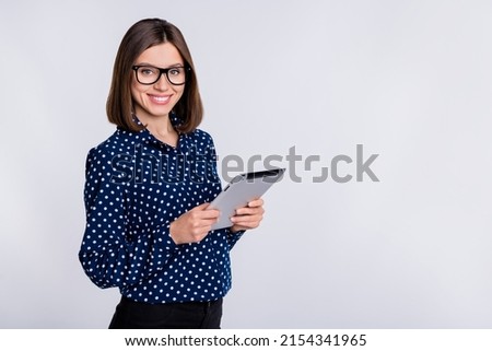 Portrait of cheerful charming girl hold tablet toothy smile empty space isolated on grey color background Royalty-Free Stock Photo #2154341965