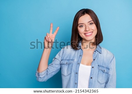 Photo of candid satisfied person hand show make v-sign toothy smile isolated on blue color background