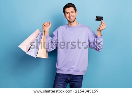Photo of nice millennial brunet guy hold bags card wear pullover jeans isolated on blue color background