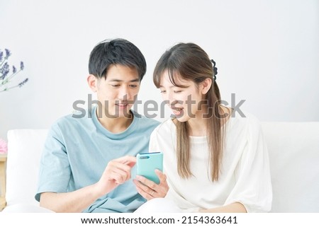 Asian couples using the smartphone at home
