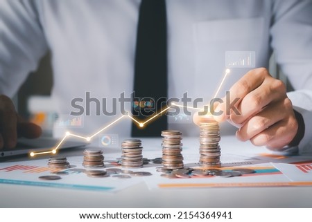Business man putting coins Business growth and investment chart, strategic planning to increase profits from doing business, long-term investment planning. Royalty-Free Stock Photo #2154364941