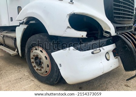 Closeup of abandoned crashed lorry after road accident on a car dump, decay on the front bumper of an white truck without headlight Royalty-Free Stock Photo #2154373059