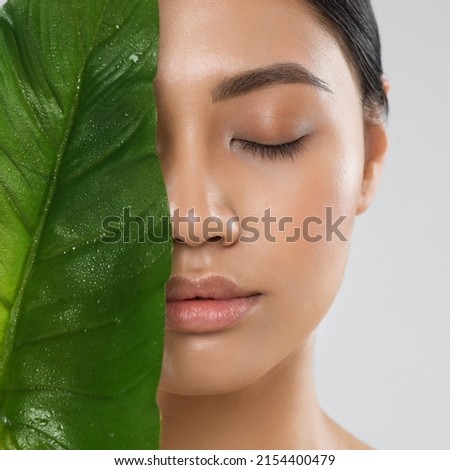 Skin Care. Natural Beauty Woman. Model with Fresh Clean Skin Make up and Full Lips with Big Green Tropic Leaf. Eco Cosmetics and Spa Cosmetology. Asian Girl Close up Portrait with Closed Eyes Royalty-Free Stock Photo #2154400479
