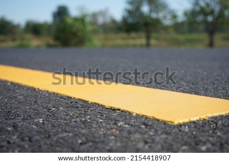Blurred image, paved road and traffic marking color yellow, bright color