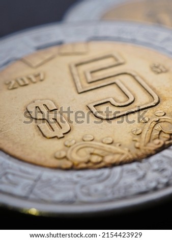 Coin of 5 five Mexican pesos close-up. Peso of Mexico. News about economy or banking. Loan and credit. Wages and money. Focus on peso symbol sign. Vertical illustration. Macro