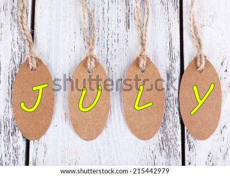 July tags on wooden background