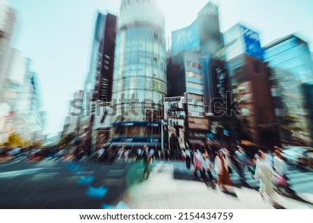 Abstract Pedestrian walking on zebra crosswalk to cross street in Ginza district, one of the most popular luxury shopping district, of Tokyo, Japan with creative zoom blur effect