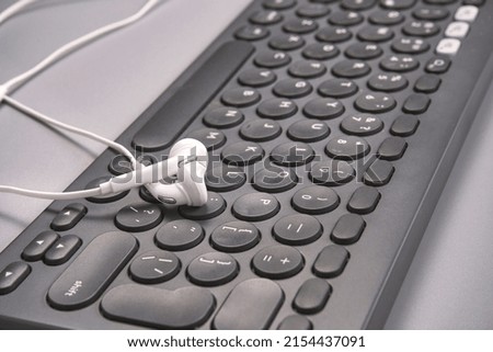 Podcast concept. Black microphone recorder, content notebook keypad with white earphones. Close up. Audio music device. Recording production. School knowledge equipment. Home online teaching. Grey