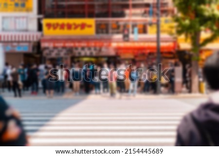 Blur Abstract of Tourists visiting Akihabara or Akiba, well known for selling anime, idol, and manga related goods on sunny day with shop and store open for business