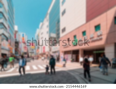 Blur Abstract of Tourists visiting Akihabara or Akiba, well known for selling anime, idol, and manga related goods on sunny day with shop and store open for business