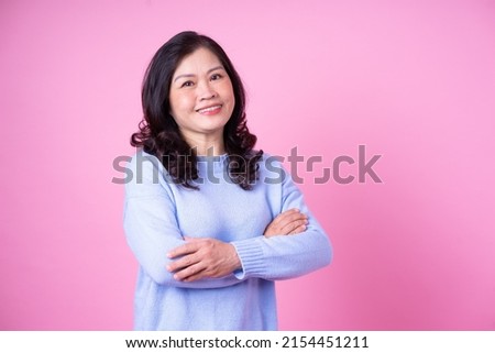 Portrait of middle aged Asian woman on pink background
 Royalty-Free Stock Photo #2154451211